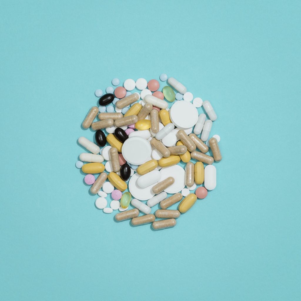 A lot of assorted pills and medicines on blue background