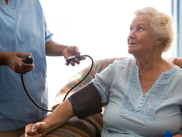 Nurse examining patient in nursing home